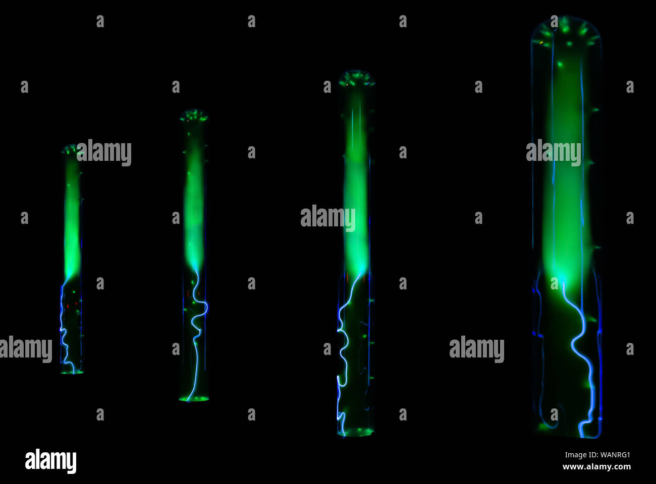 Un fulmine e incandescente verde di scariche elettriche in beute con gas inerte su sfondo nero Foto Stock