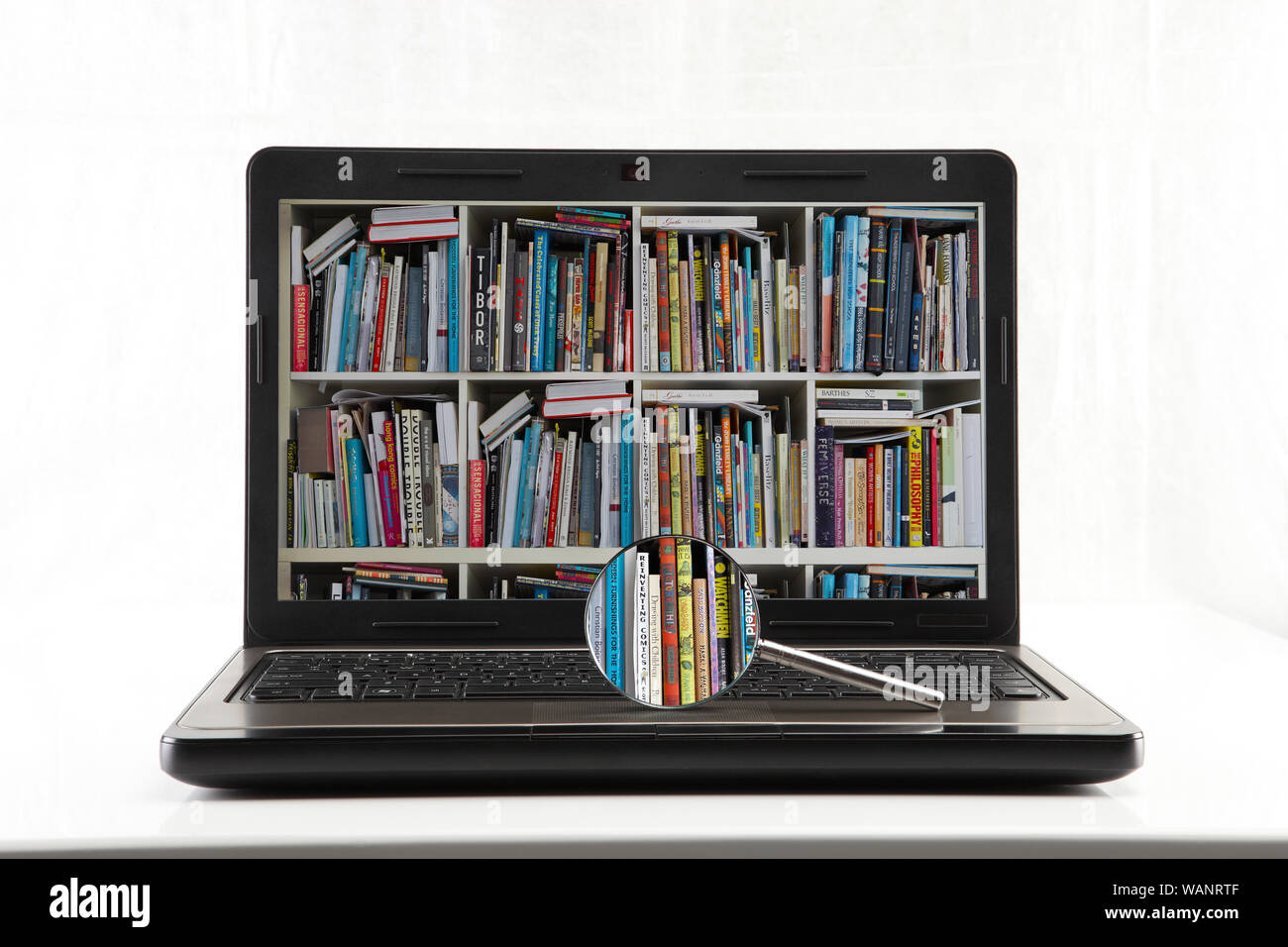Formazione e-learning e libreria internet con lente d'ingrandimento isolata su sfondo bianco Foto Stock