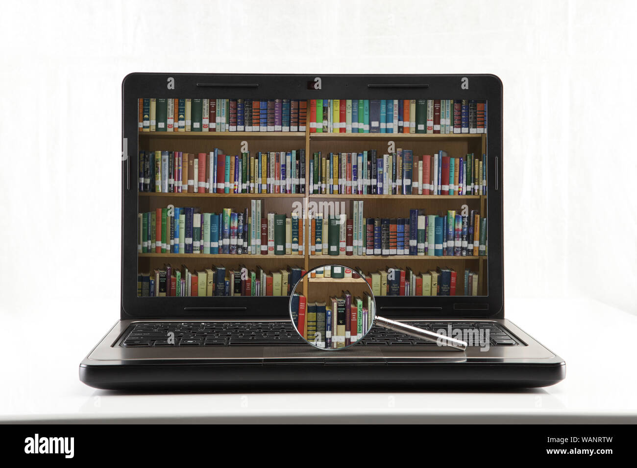 Formazione e-learning e libreria internet con lente d'ingrandimento isolata su sfondo bianco Foto Stock