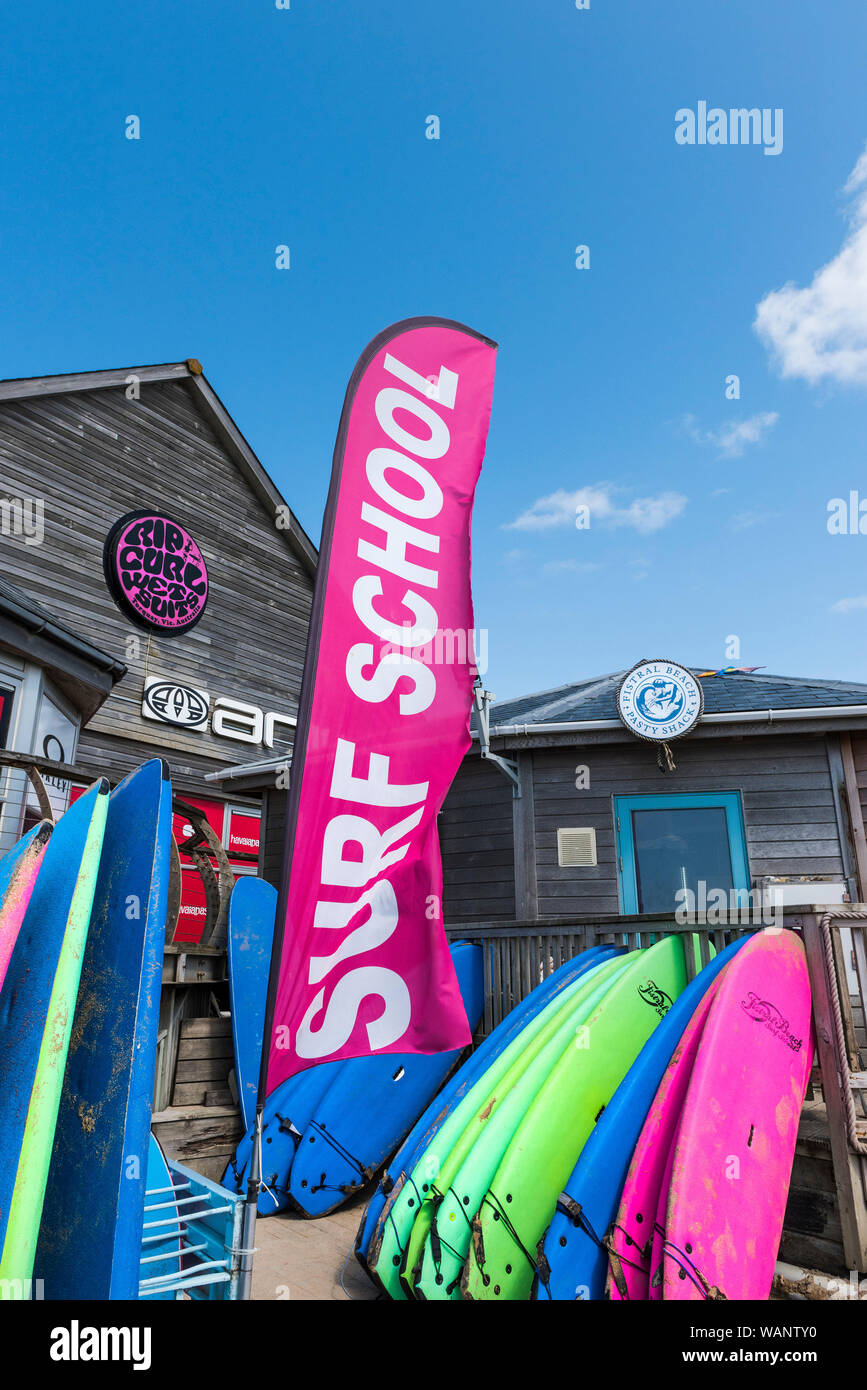 Un colorato luminosamente banner pubblicitari il Fistral Surf School a Newquay in Cornovaglia. Foto Stock