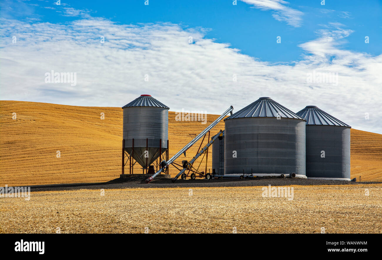 Washington, Regione Palouse, campi di grano caduta stagione dopo il raccolto, tondo corrugò acciaio grano strutture di archiviazione Foto Stock