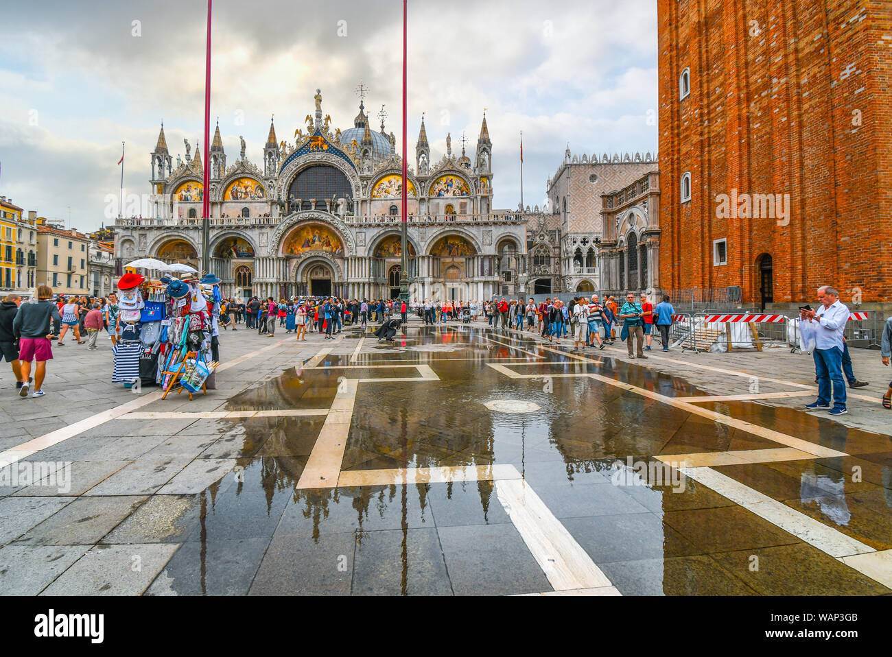 I turisti affollano Piazza San Marco di fronte alla Basilica dopo un diluvio come l'acqua inizia a retrocedere a Venezia, Italia Foto Stock