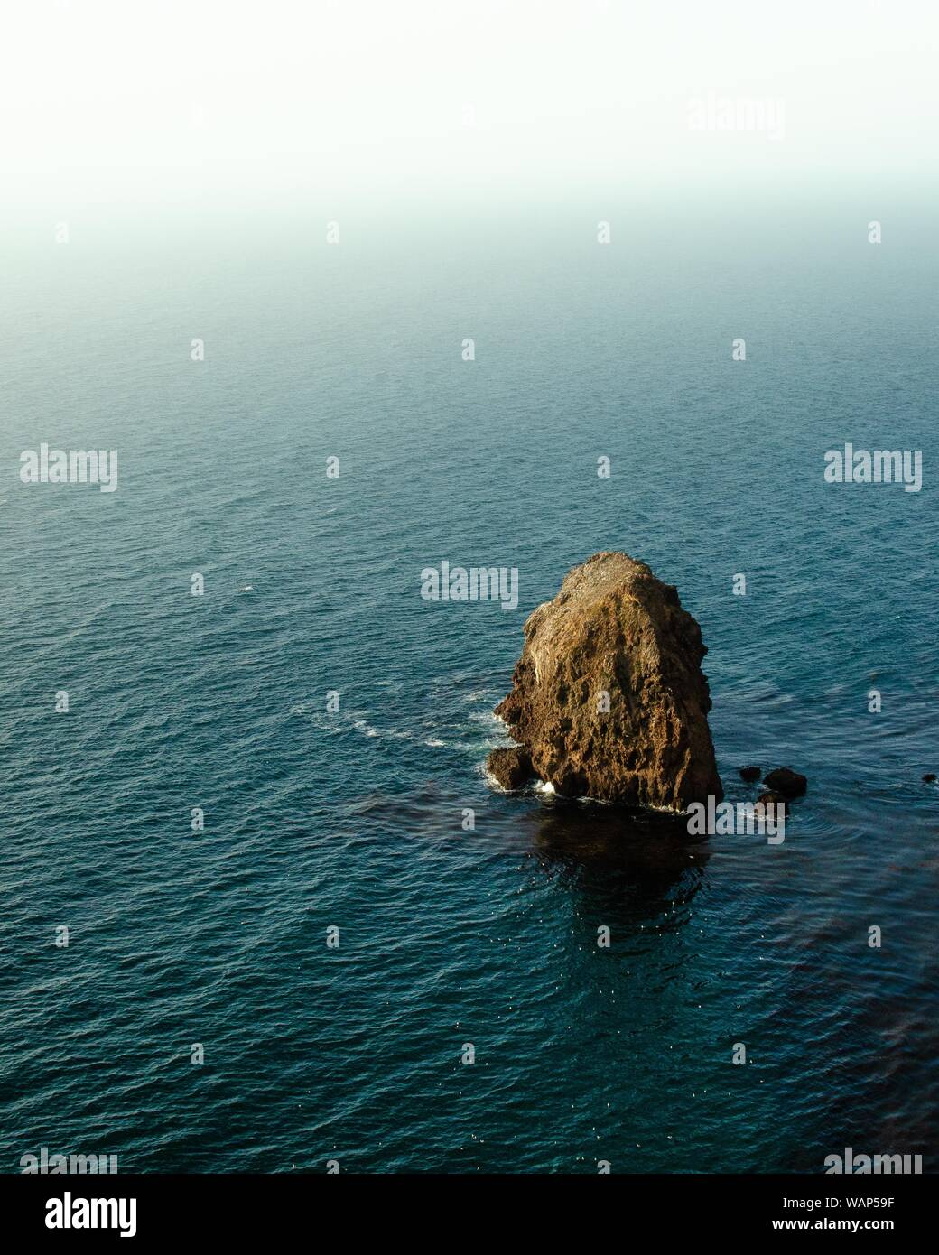 Bellissimo scatto di una formazione rocciosa nel mezzo di le acque calme del mare di giorno Foto Stock