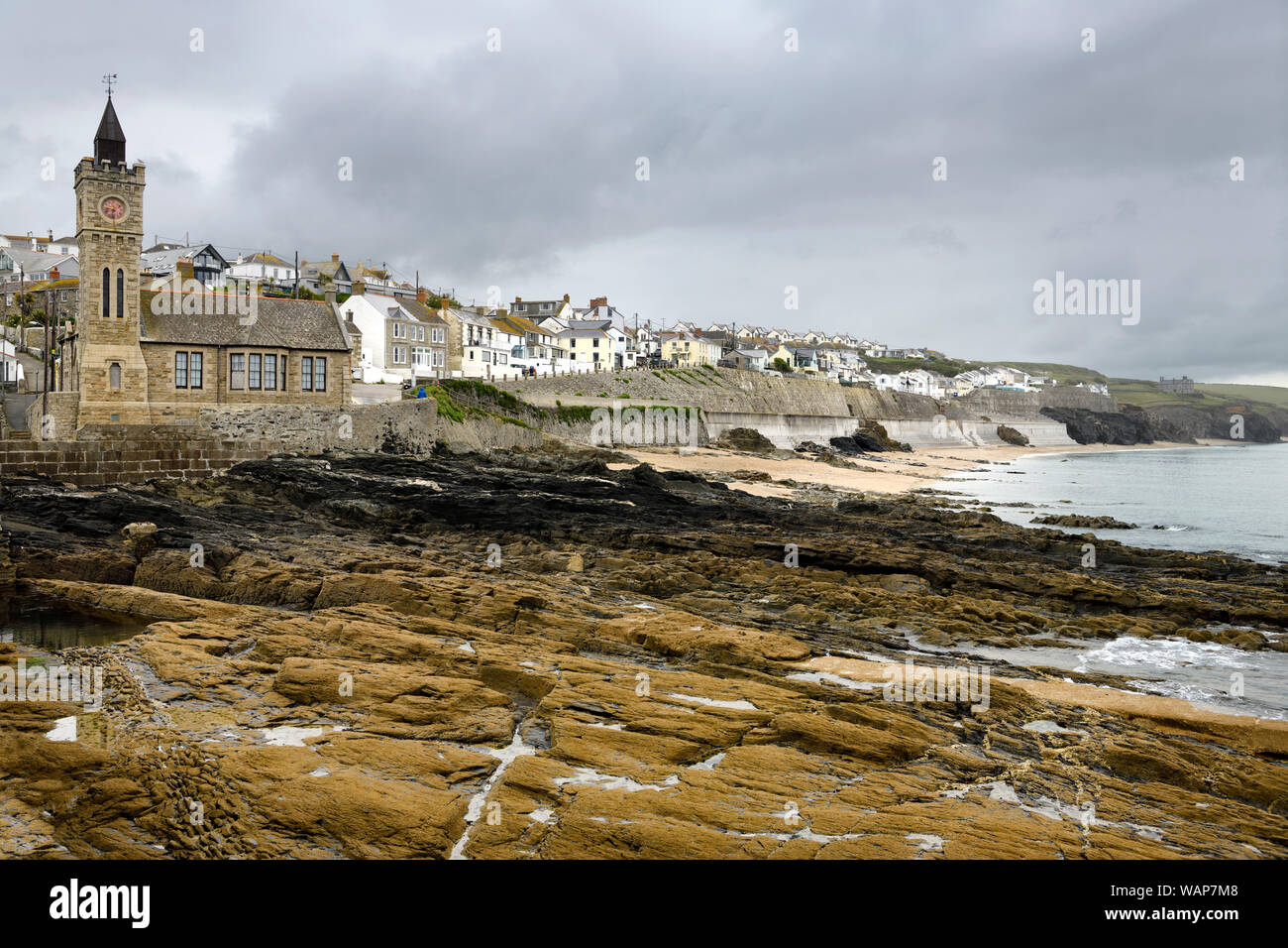 Bickford smith institute ora Porthleven consiglio comunale edificio con torre dell orologio accanto a Porthleven spiaggia e rocce stratificate dal Molo Cornwall Englan Foto Stock