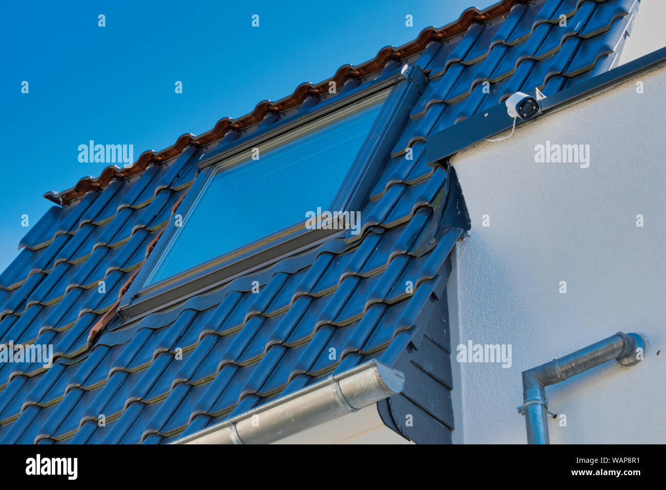 Nuova costruzione tetto con finestra sul tetto contro il cielo senza nuvole in Germania Foto Stock