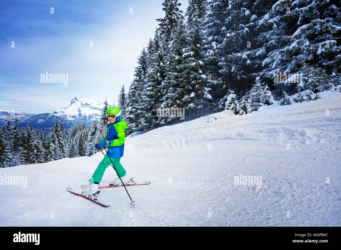 Ragazzo in casco e maschera ski in discesa girare a testa indietro Foto Stock