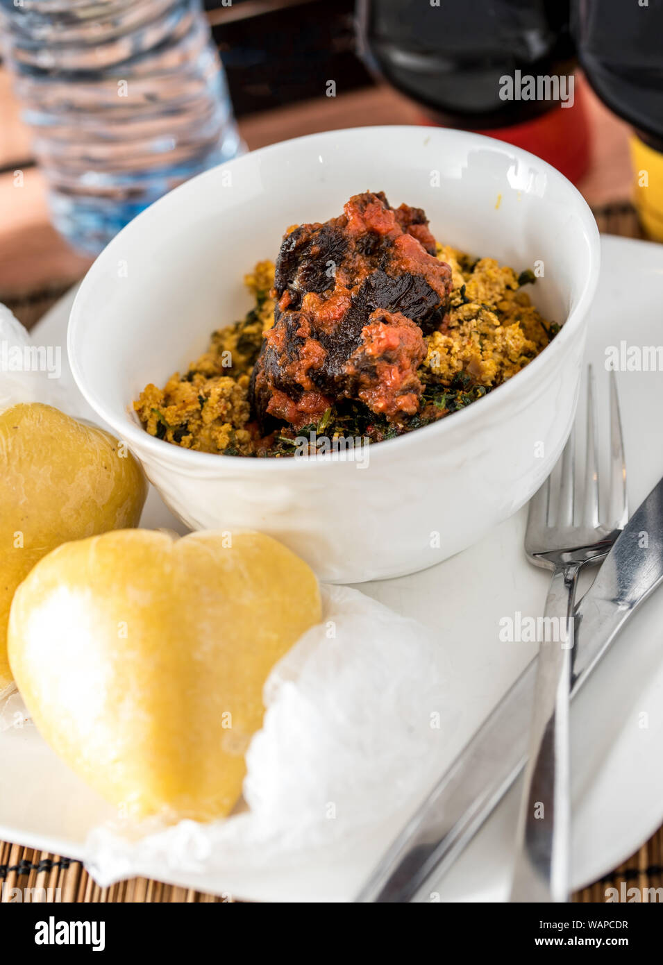 Regionali africani il cibo sulla piastra bianca su sfondo di legno Foto Stock