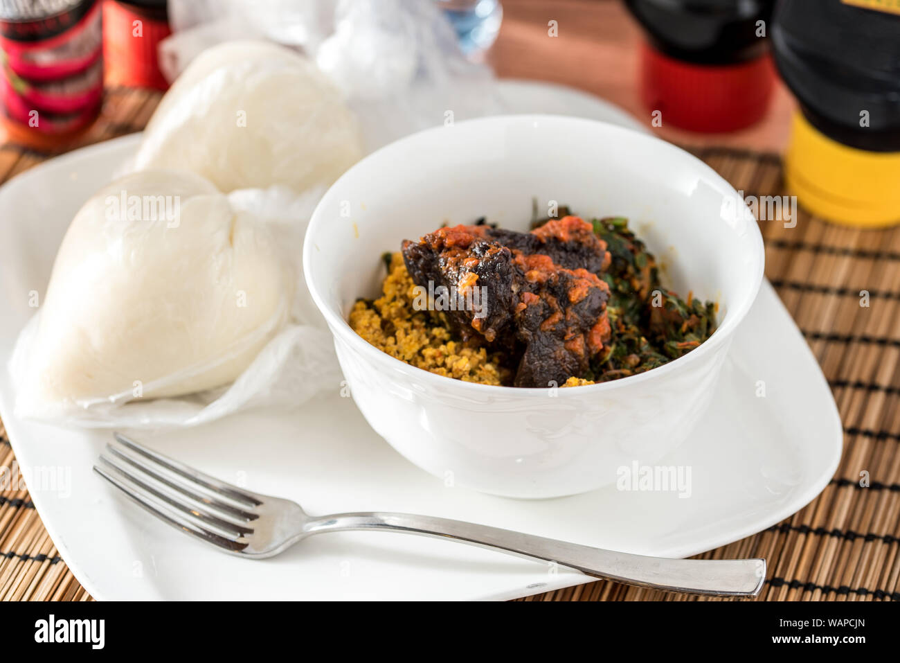 Regionali africani il cibo sulla piastra bianca su sfondo di legno Foto Stock