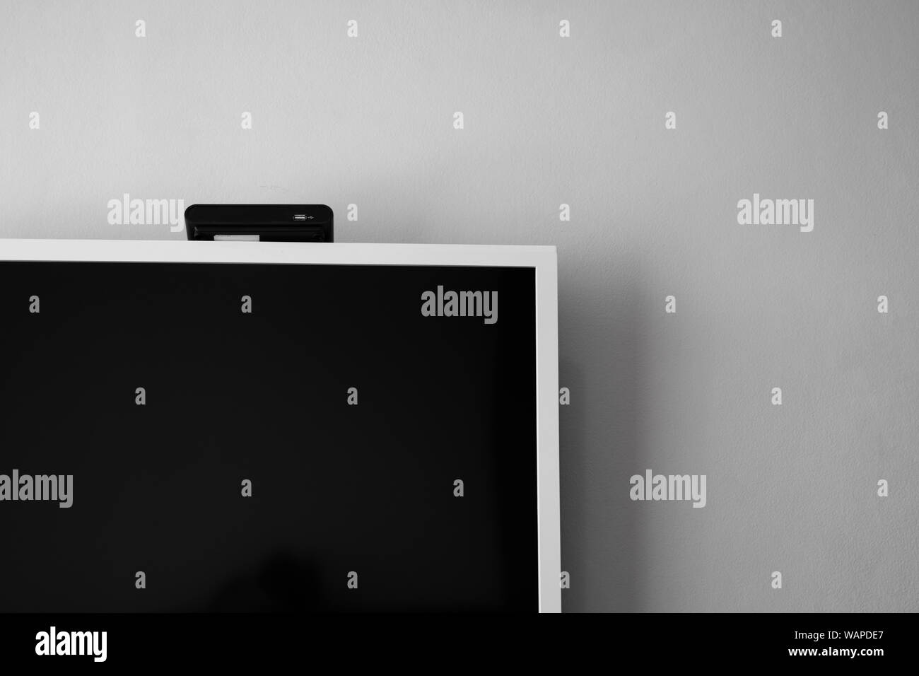 A LED o LCD schermo tv appesi al muro con un sintonizzatore TV in camera per la decorazione di interni design. Casa confortevole Foto Stock