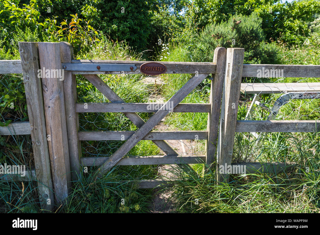 Azienda privata terreno recintato da un grande cancello con un privato di tenere fuori segno indicante nessun accesso al percorso rurale Foto Stock