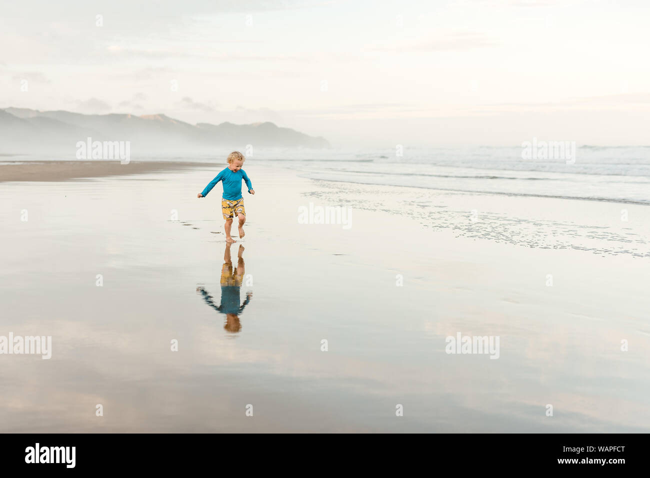 Bambino in esecuzione su una spiaggia in Nuova Zelanda Foto Stock