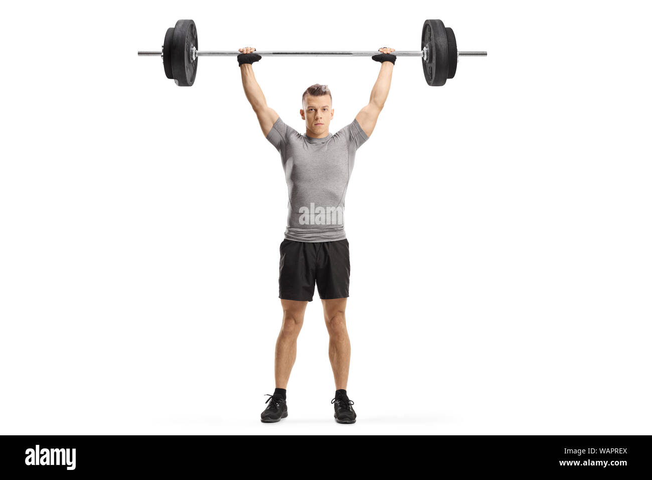 A piena lunghezza Ritratto di una giovane ragazzo muscolare sollevamento pesi isolato su sfondo bianco Foto Stock