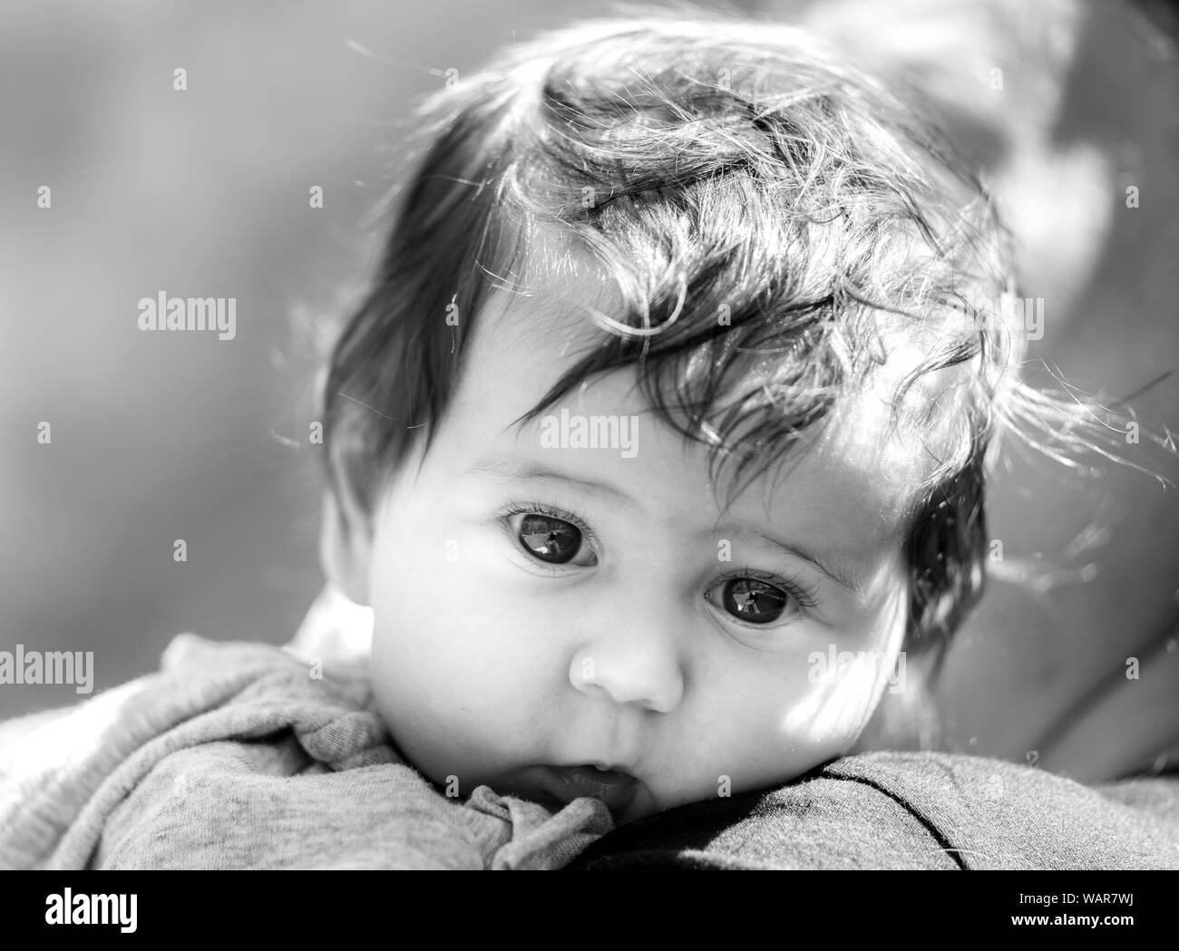 Fotografia in bianco e nero di un simpatico baby guardando la telecamera Foto Stock