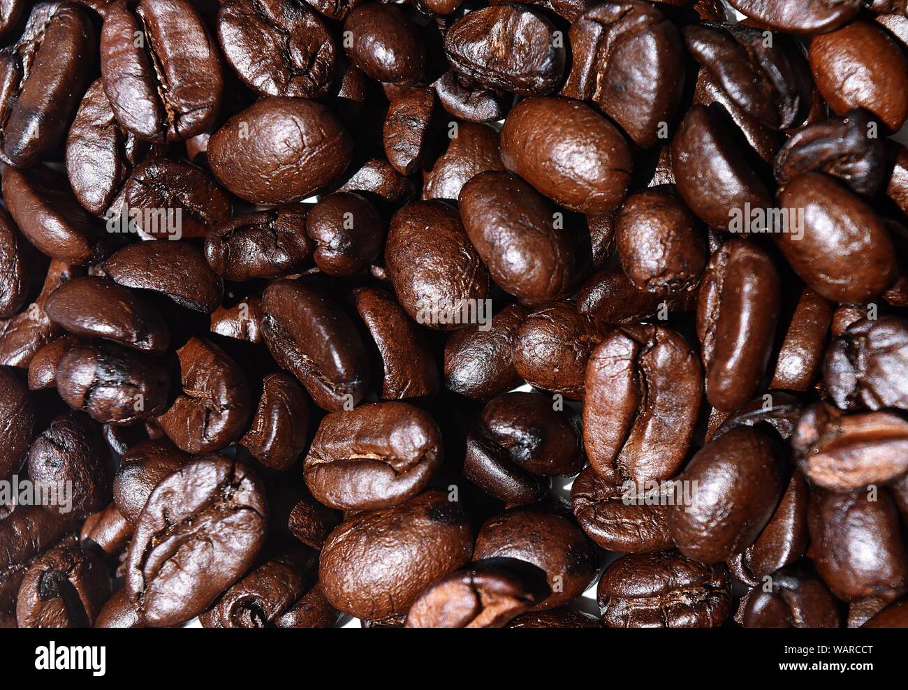 Close-up marrone scuro caffè torrefatto in grani, materie alimenti trasformati per un drink rinfrescante. Foto Stock