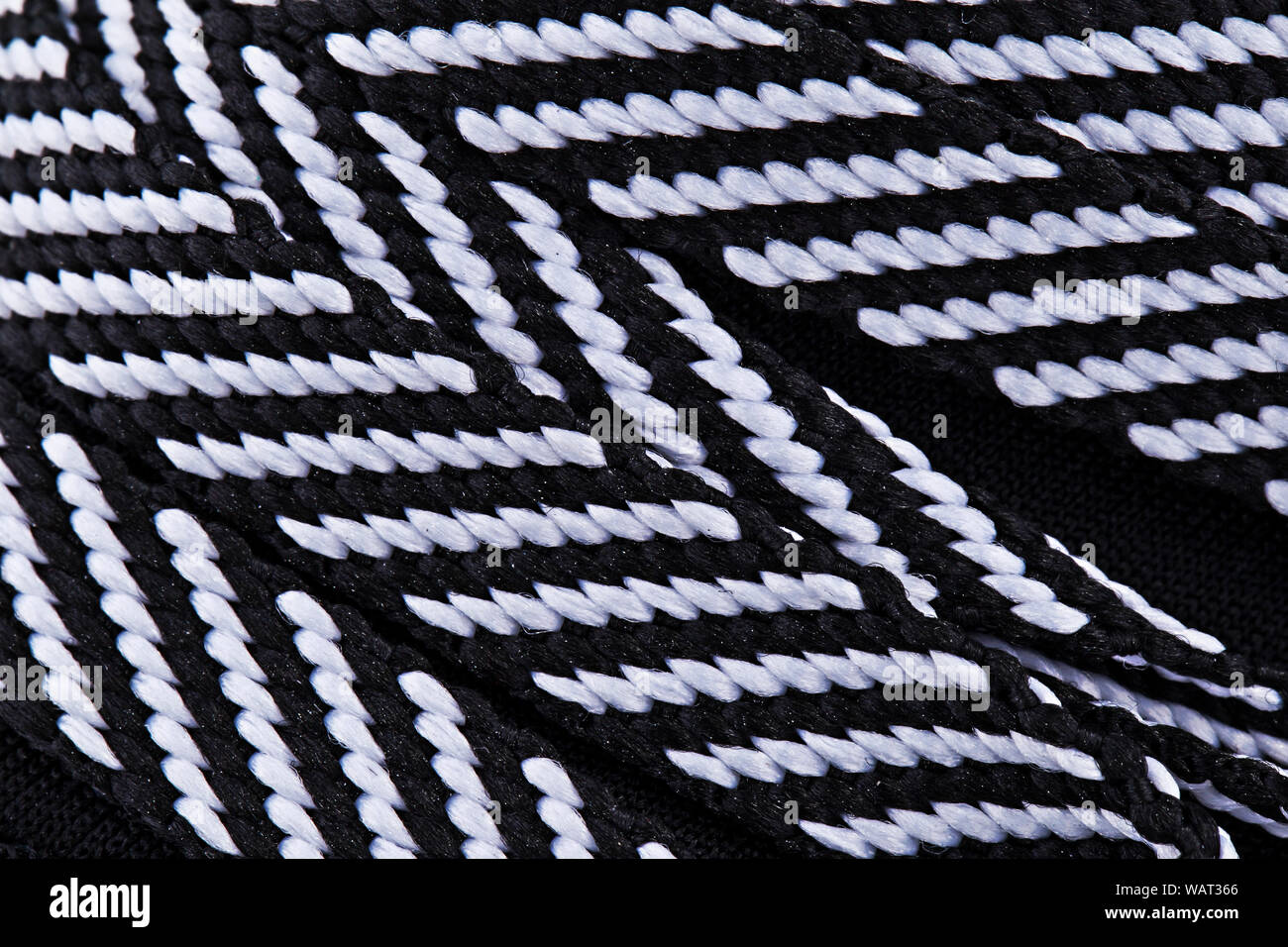 Frammento di bianco e nero in tessuto sneaker. La consistenza del materiale di calzature sportive Foto Stock
