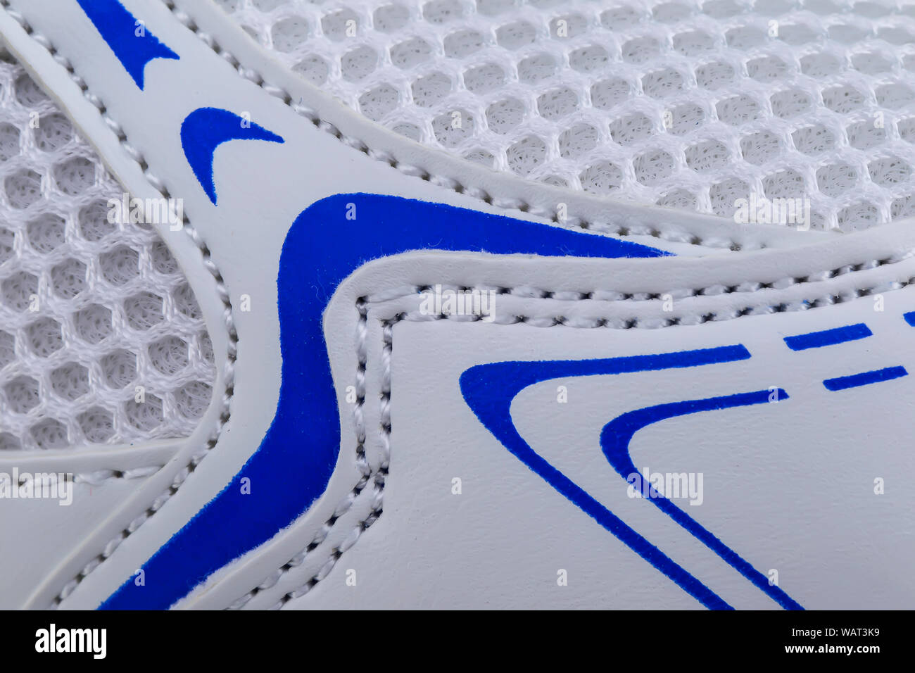 Frammento di bianco e tessuto blu sneaker. La consistenza del materiale di calzature sportive Foto Stock