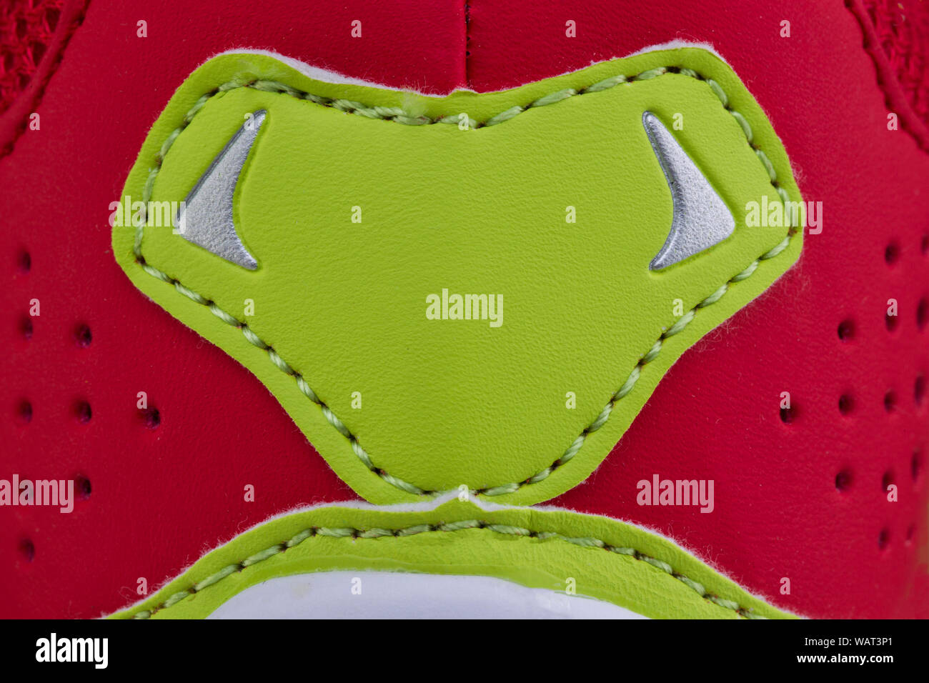 Frammento di un panno rosso sneaker con una striscia verde. La consistenza del materiale di calzature sportive Foto Stock
