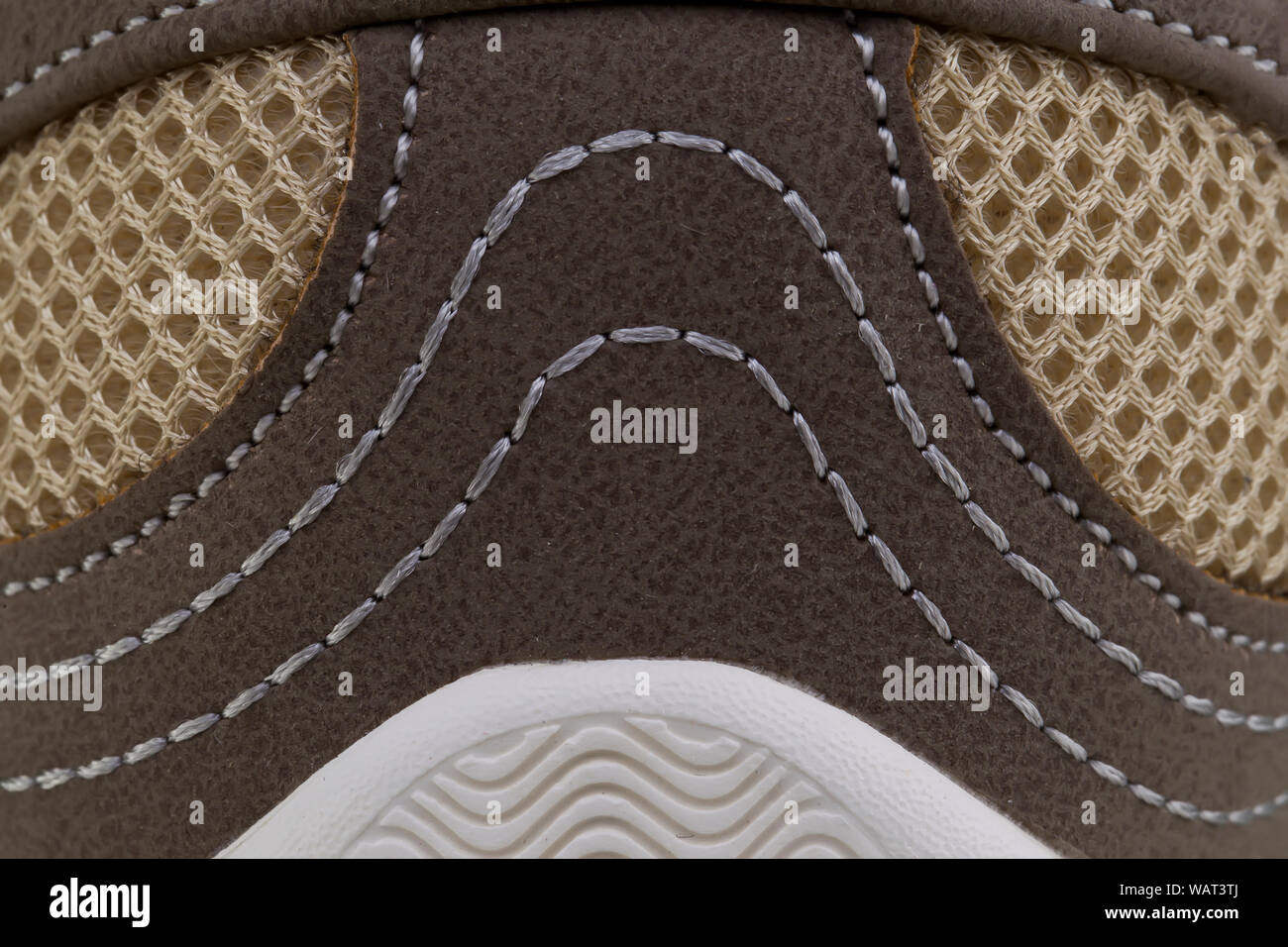 Frammento di un tessuto marrone sneaker con cuciture di colore bianco. La consistenza del materiale di calzature sportive Foto Stock