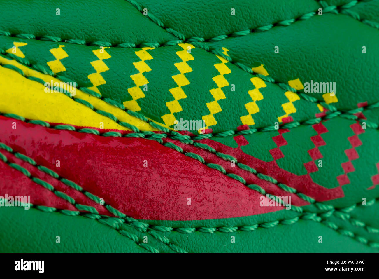 Frammento di un verde-rosso sneaker. La consistenza del materiale di calzature sportive Foto Stock