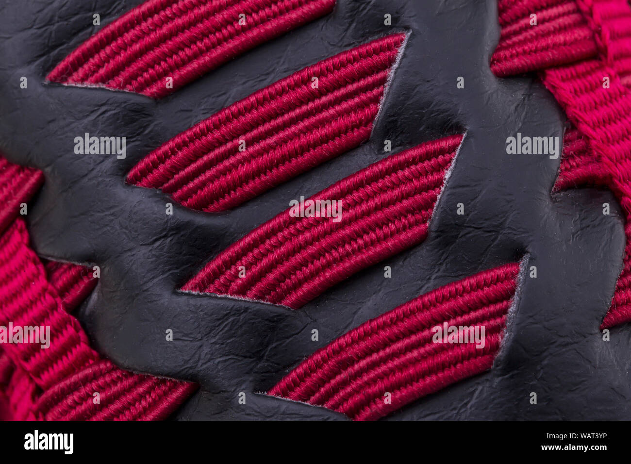 Frammento di rosso e nero sneaker tessuto. La consistenza del materiale di calzature sportive Foto Stock