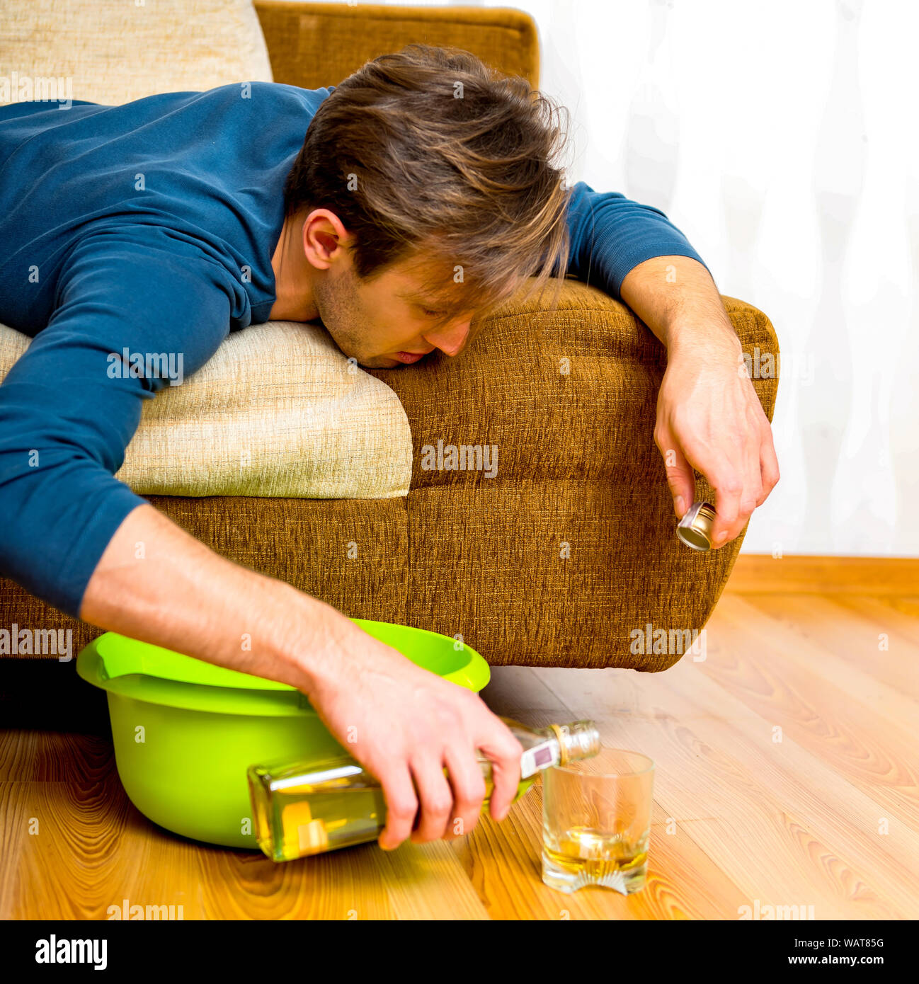 Uomo ubriaco wiskey versatore in vetro. Egli è frustrato. Dipendenza da alcool. Foto Stock