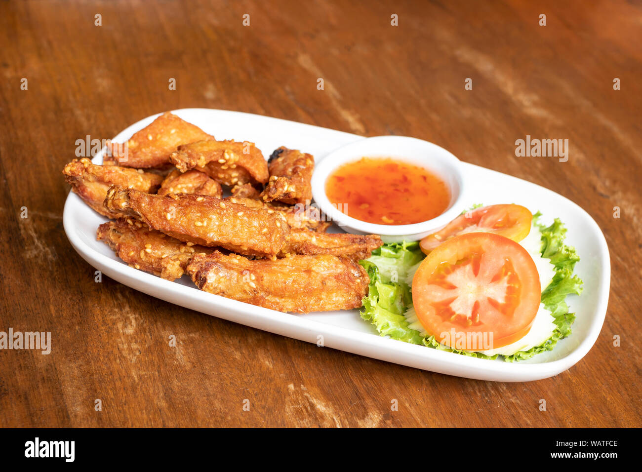 Alette di pollo fritte con salsa di pollo sul piatto. Foto Stock