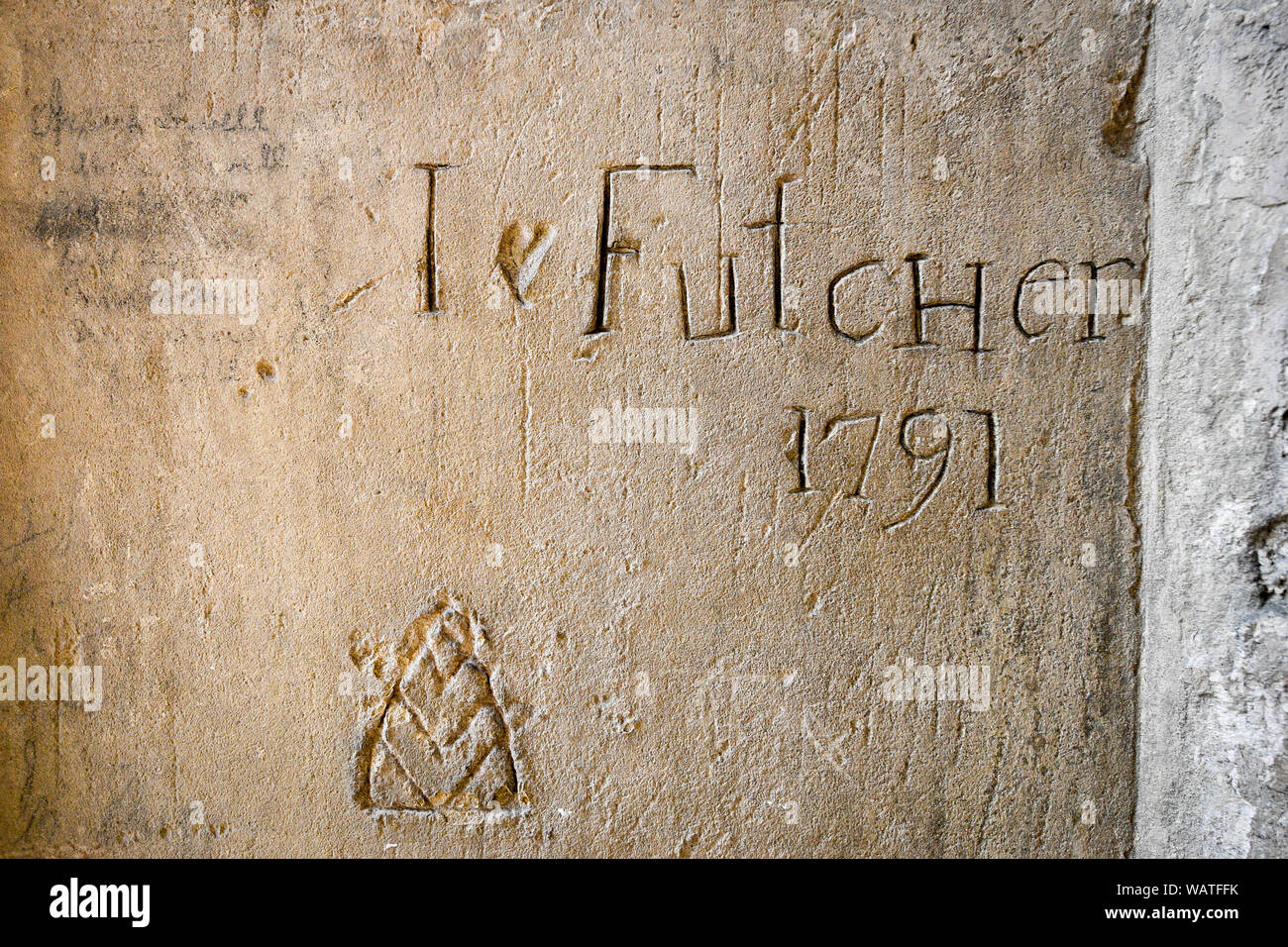 Graffiti graffiato internamente in un muro di pietra calcarea, probabilmente lasciato da un artigiani, con probabile aggiunta di cuore più tardi, che può essere visto durante la Cattedrale di Salisbury Tower Tour, dove i visitatori sono guidati fino alla base dei 123 metri a guglia, arrampicata 332 principalmente a spirale, passi attraverso il soffitto a volte lo spazio del tetto, passato medievale di vetro macchiato e attraverso il funzionamento interno della cattedrale del XIII secolo. Foto Stock