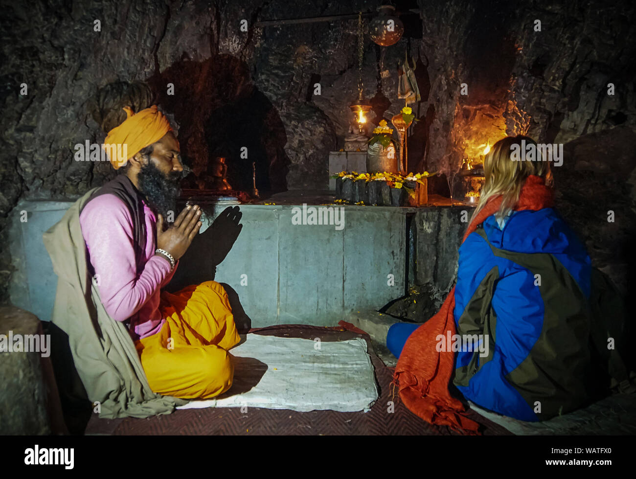 Babba, un santo uomo in India, un mentore di credenti, prega per i suoi discepoli in una grotta sacra nella parte anteriore delle statue di divinità indiane. 11 gennaio 2018: Foto Stock