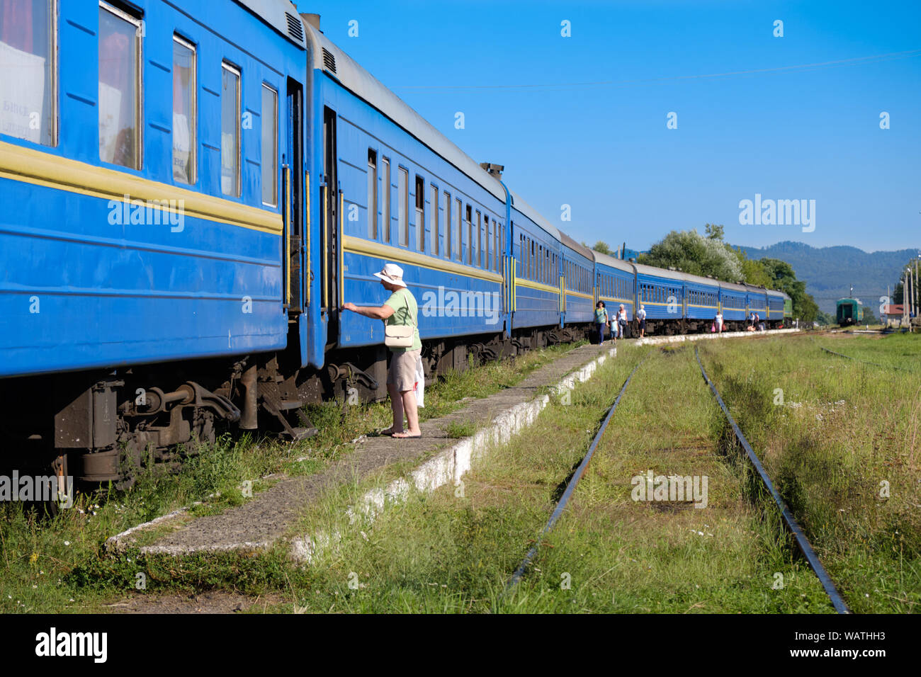 L'imbarco dei passeggeri di un blu ucraino sleeping car carri, come il treno lungo si trova in corrispondenza della stazione piattaforma. Solotvino, Ucraina - 19 Agosto, 2019 Foto Stock