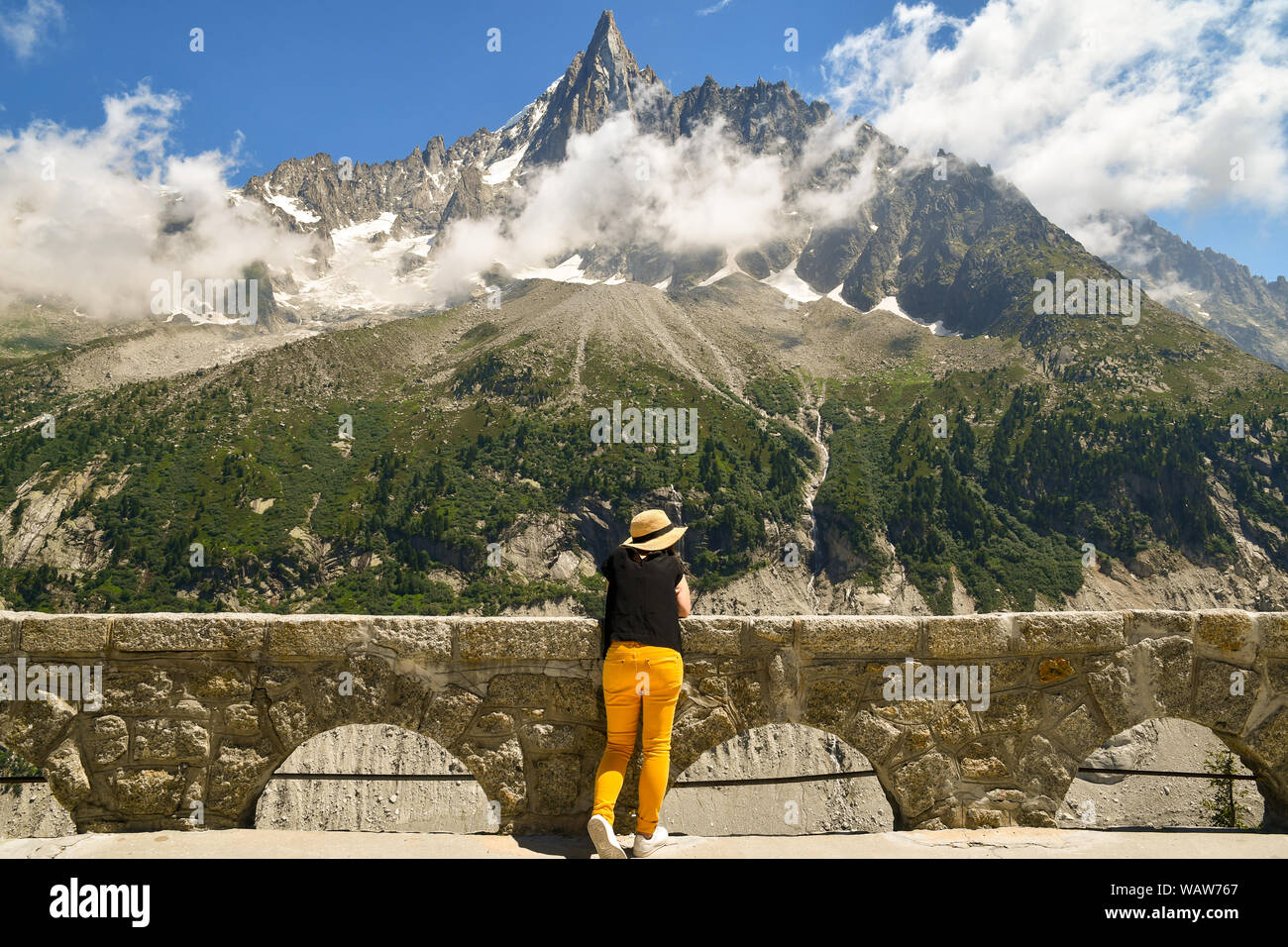 Un turista da dietro ammirando la vista di Aiguilles du Dru, una montagna del massiccio del Monte Bianco nelle Alpi francesi, Montenvers, Chamonix, Francia Foto Stock