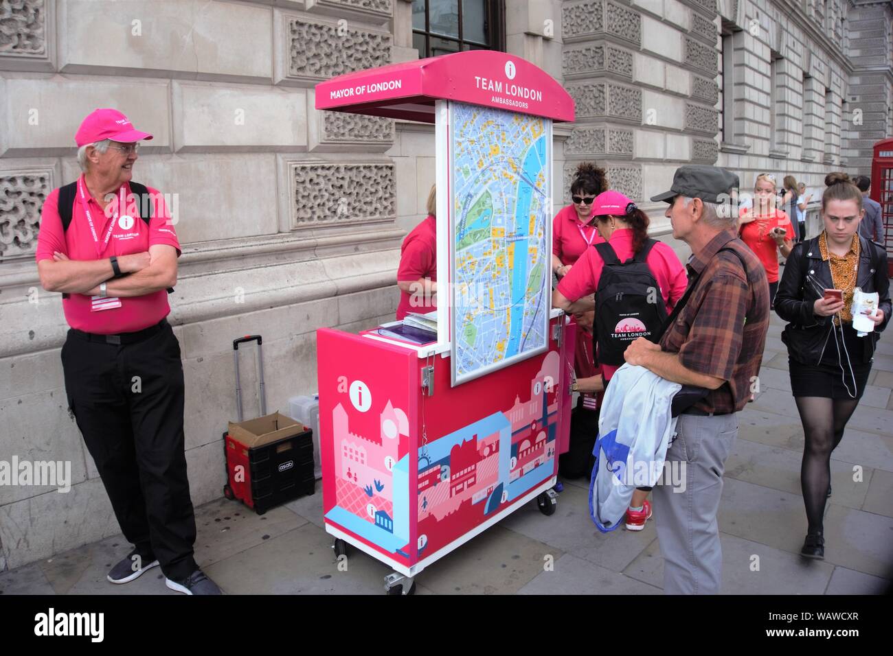 I volontari del Team di Londra nel loro abito rosa darà informazioni turistiche durante la stagione estiva in Westminster, Londra, Regno Unito Foto Stock