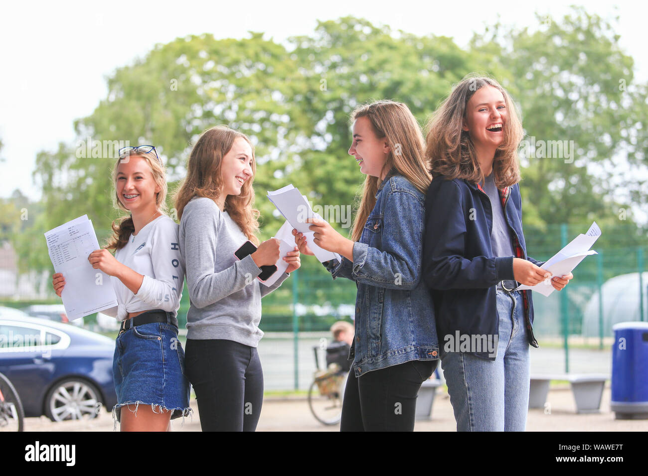 GCSE risultati esame giorno. Gli studenti con i risultati dei loro esami lettere al di fuori di una scuola secondaria Foto Stock