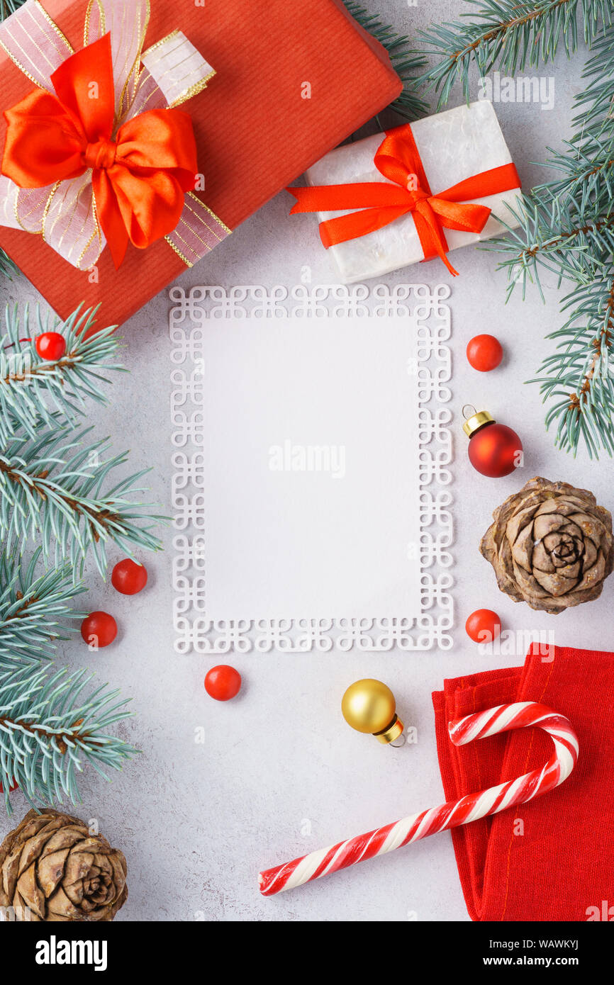 Sfondo di natale con uno spazio vuoto. Wishlist mockup. Decorazioni di Natale, rosso confezioni regalo e candy cane. Scatto dall'alto. Foto Stock