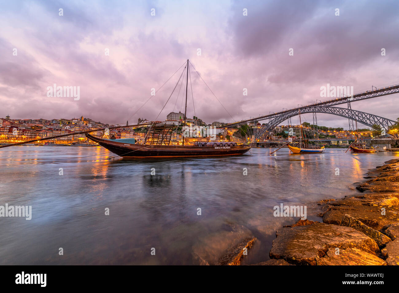 Vista sul Rio Douro al tramonto a Porto con le tradizionali imbarcazioni porta in primo piano. Foto Stock
