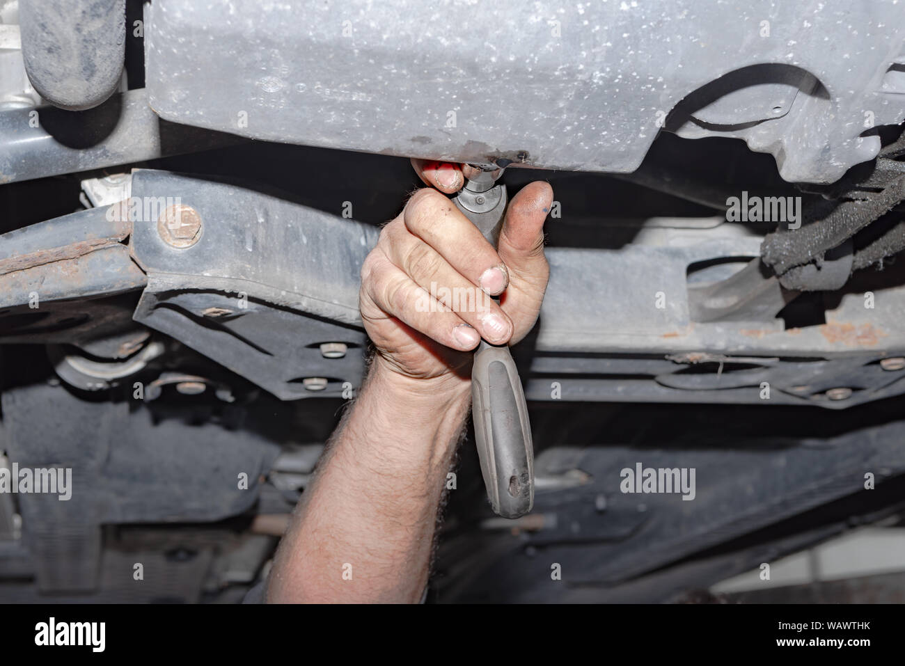 Meccanico al lavoro. Fissare la vite con il cacciavite a batteria Foto Stock