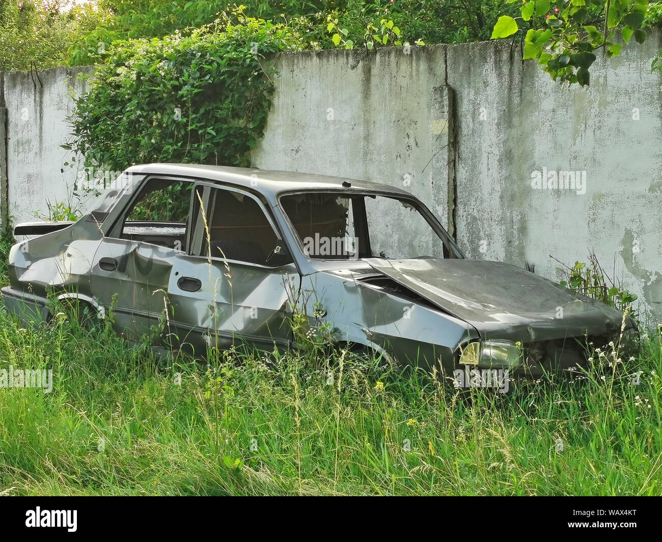 Abbandonato scatafascio auto dopo un incidente stradale sul lato della strada Foto Stock