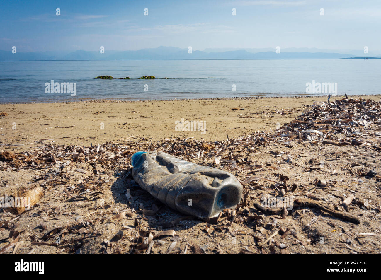 Lastic bottiglia riempita di sabbia sulla spiaggia - di rifiuti di plastica in mare Foto Stock