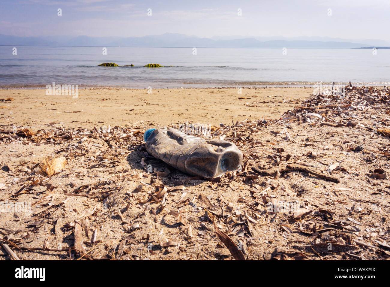 La bottiglia di plastica riempito di sabbia sulla spiaggia - di rifiuti di plastica in mare Foto Stock