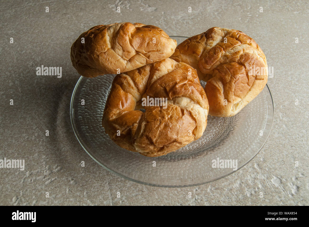 I croissant su una platein tasto scuro luce, oscurità cibo fotografia. Foto Stock