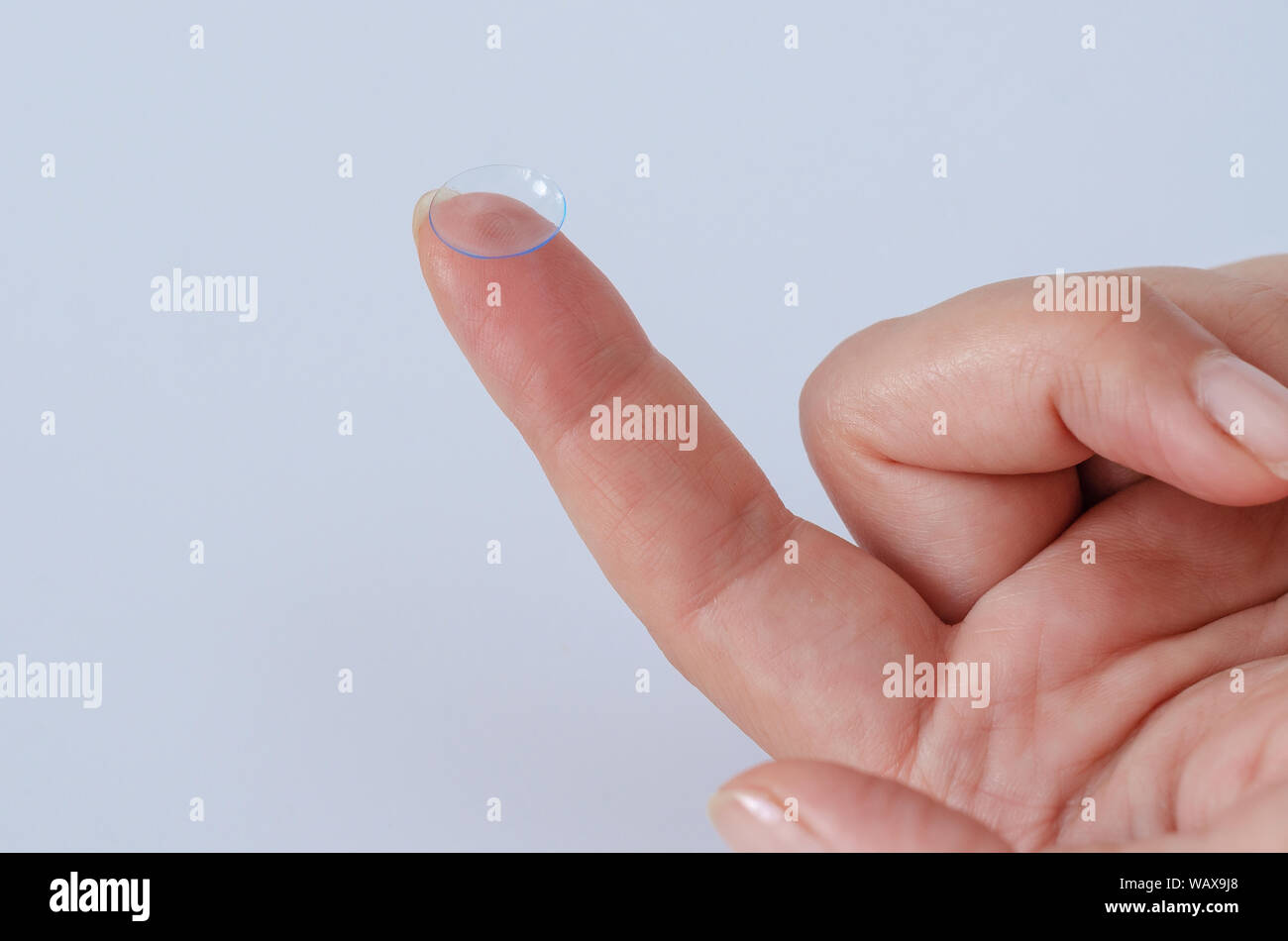 Lente a contatto di close-up su una donna del polpastrello. Buona visione, all'ottico optometrista, trattamento. Foto Stock