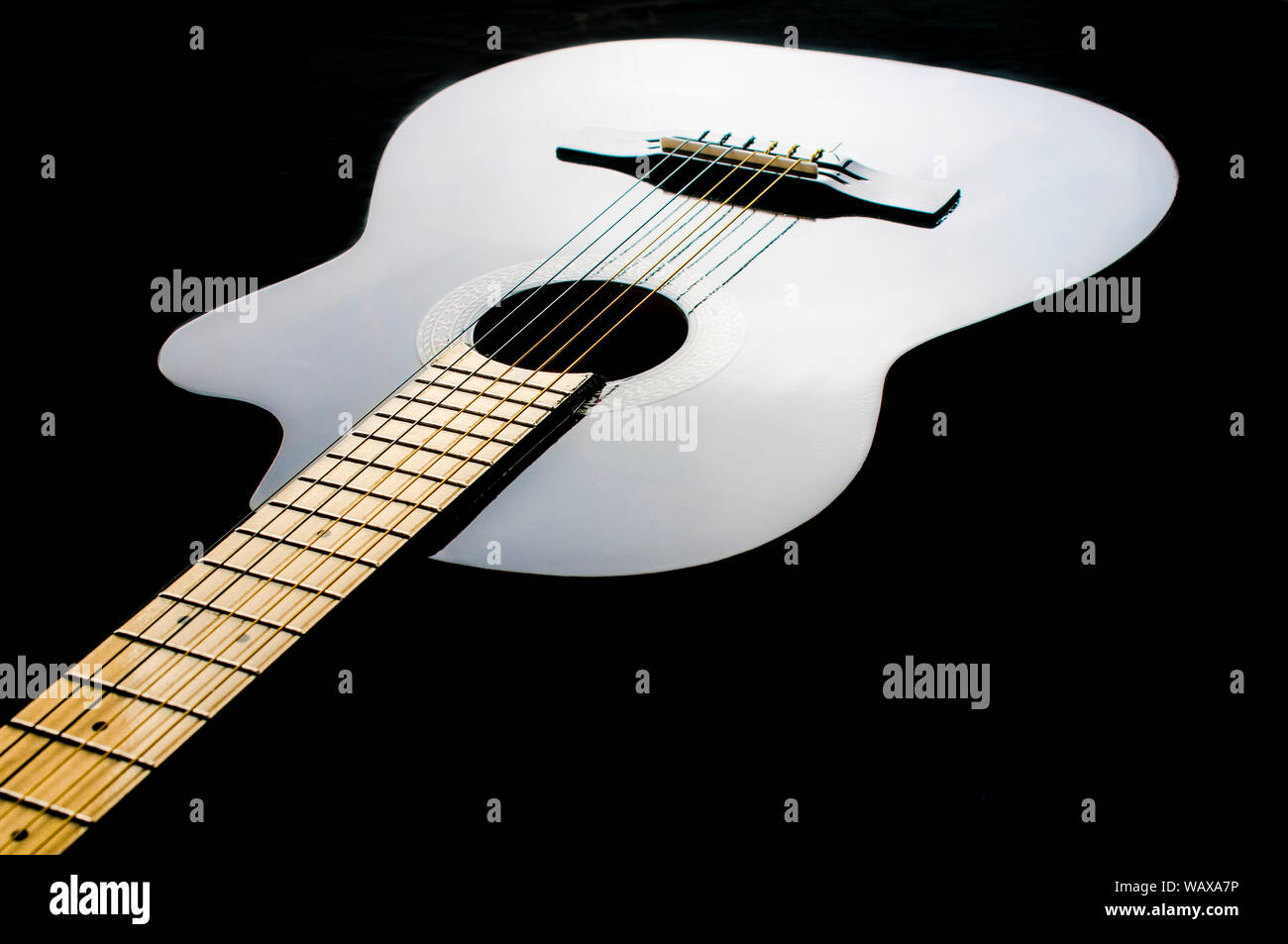 Chitarra acustica in uno sfondo nero come parte di bassa luce chiave fotografia Foto Stock