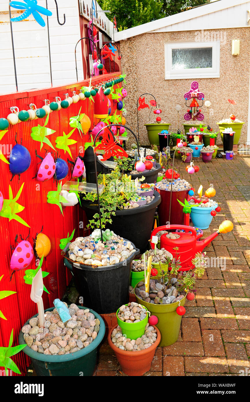 Giardino di ciottoli con plastica colorata coccinelle Foto Stock