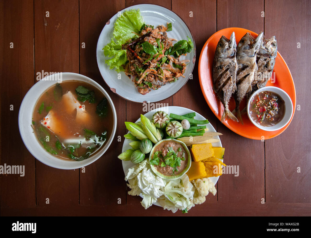 Nam Prik Pla a, Pesce fritto, Pesce speziato insalata, Tom Yum soup - Thai street food il pranzo insieme e verdure fresche, zucca, cetriolo, fagiolo e cavolfiore Foto Stock