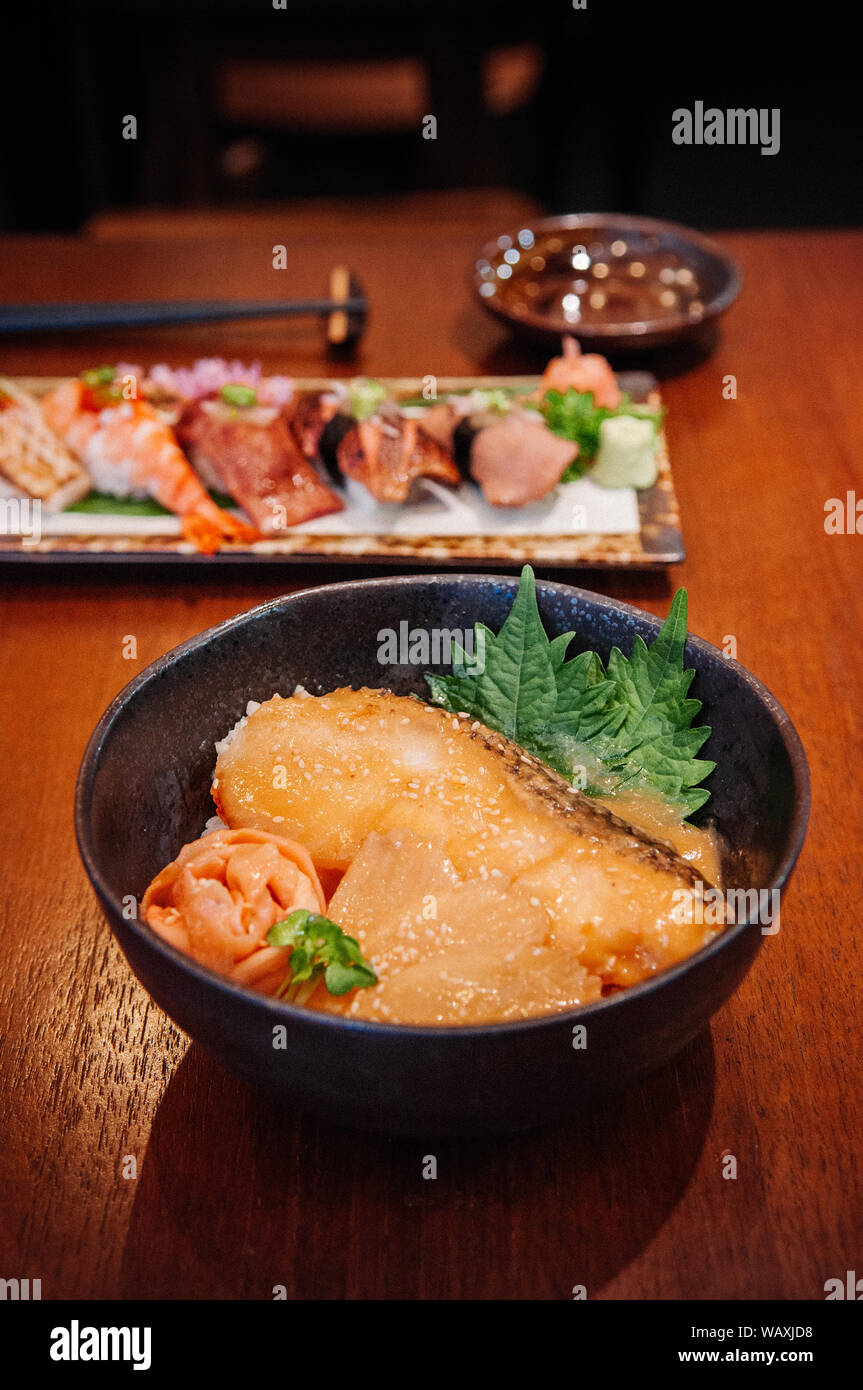 Giapponese grigliate di pesce di neve Donburi ciotola di riso e mescolare sushi premium su tavola di legno nel ristorante Foto Stock