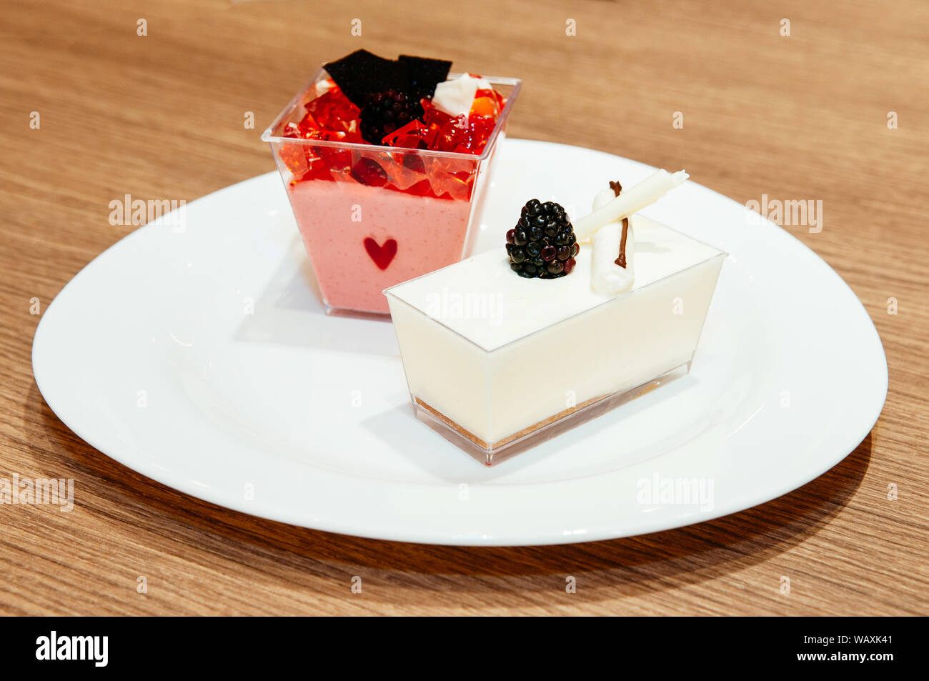 Fragole fresche e budino di latte con gelatina di fragola, il cioccolato, il cioccolato bianco e fresco blackberry su piastra bianca Foto Stock