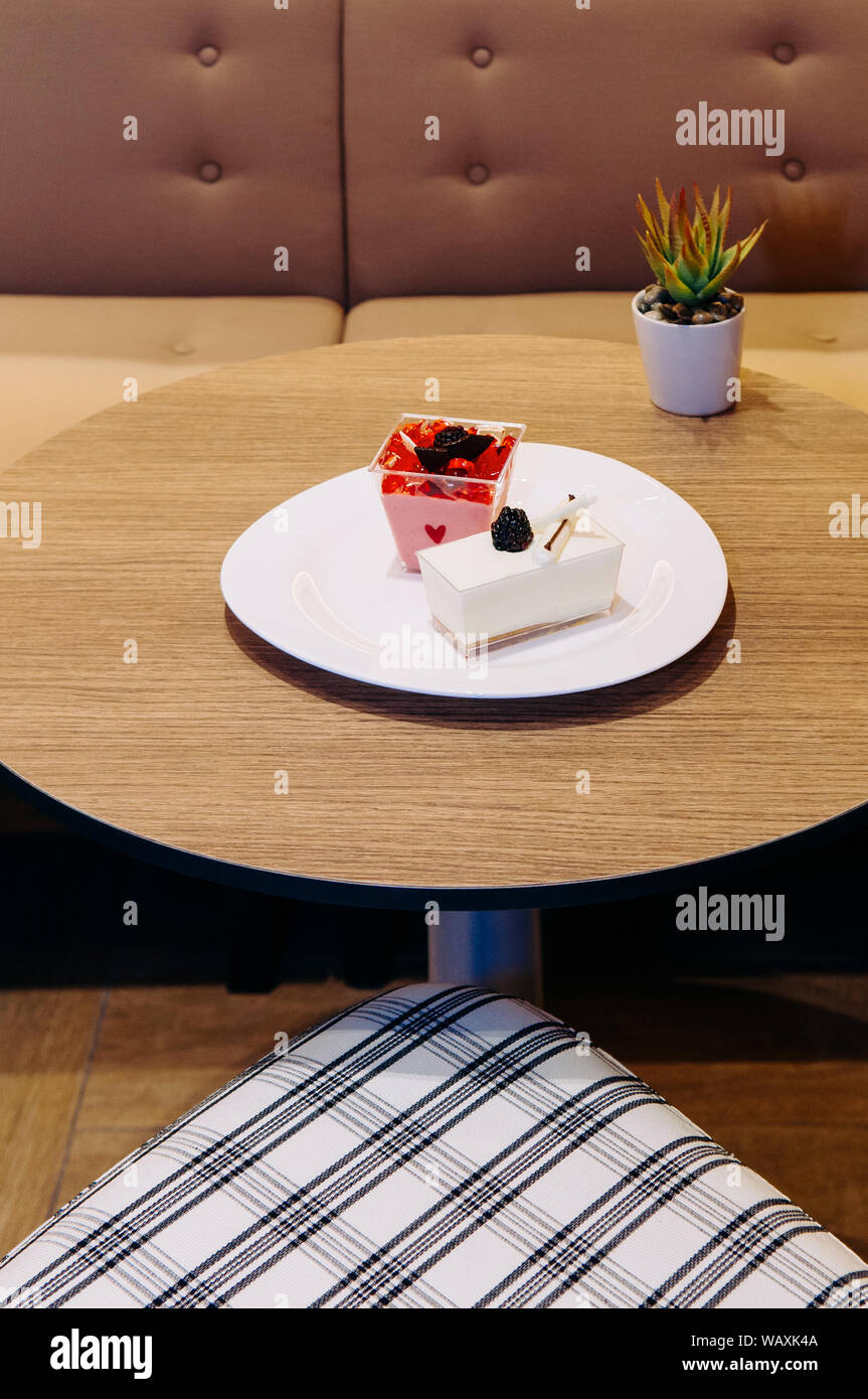 Fragole fresche e budino di latte con gelatina di fragola, il cioccolato, il cioccolato bianco e fresco blackberry su piastra bianca Foto Stock