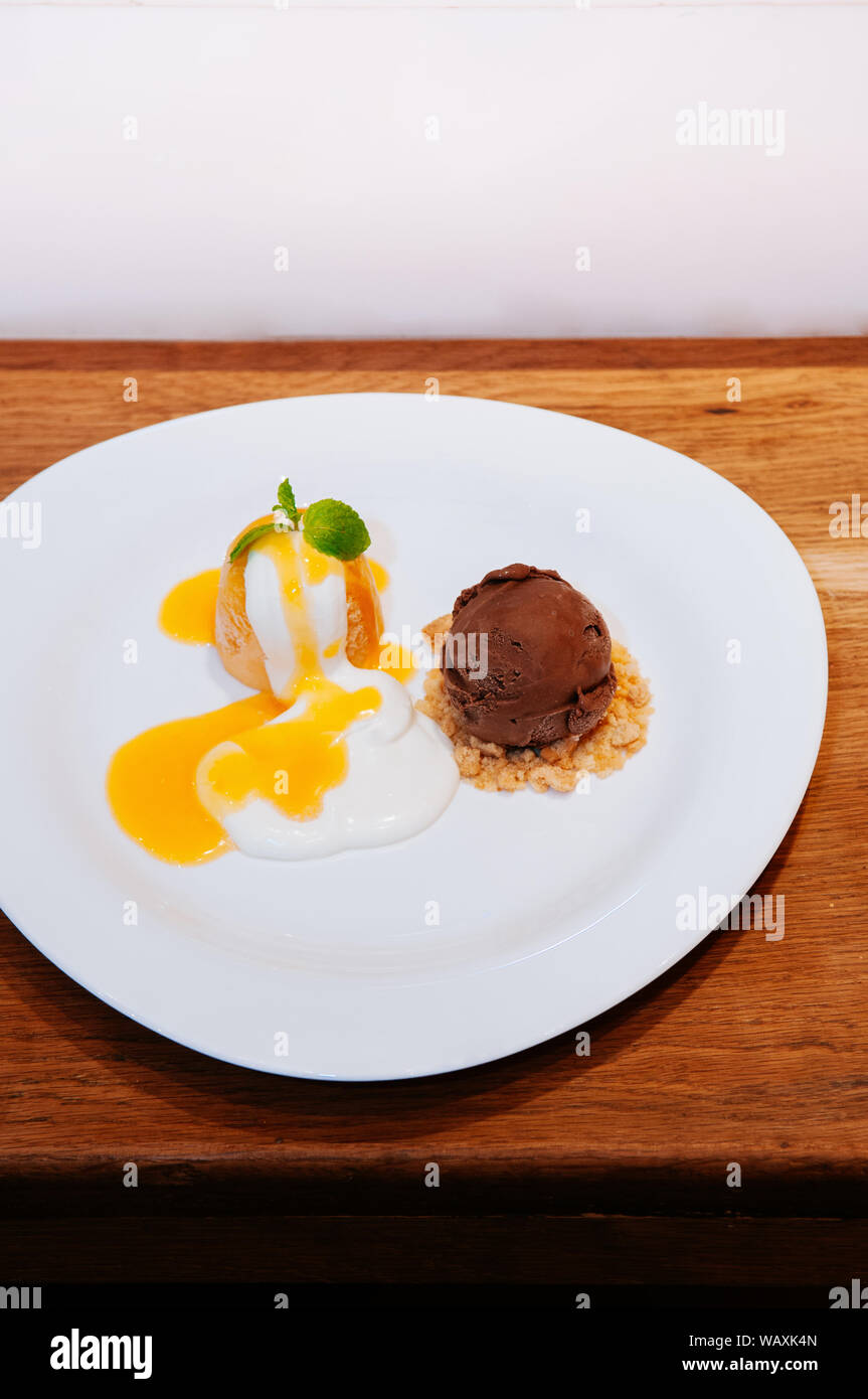 Fresche dolce freddo & arancia acida pudding con gelato al cioccolato, sbriciolate e salsa Foto Stock