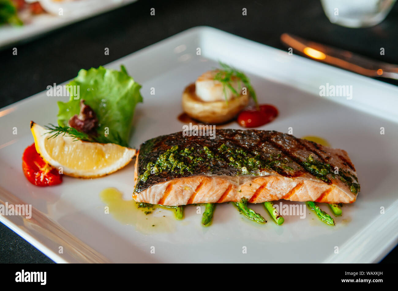 Bella la deliziosa bistecca di salmone alla griglia con asparagi e pesto, raffinata cucina Foto Stock