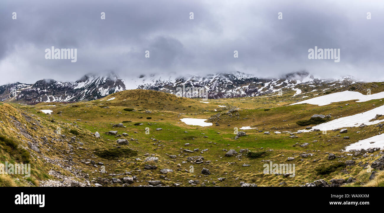 Montenegro, XXL panorama del Parco Nazionale del Durmitor highlands natura paesaggio in springtide a snowmelt parzialmente coperto da neve e nascosti in montagna Foto Stock