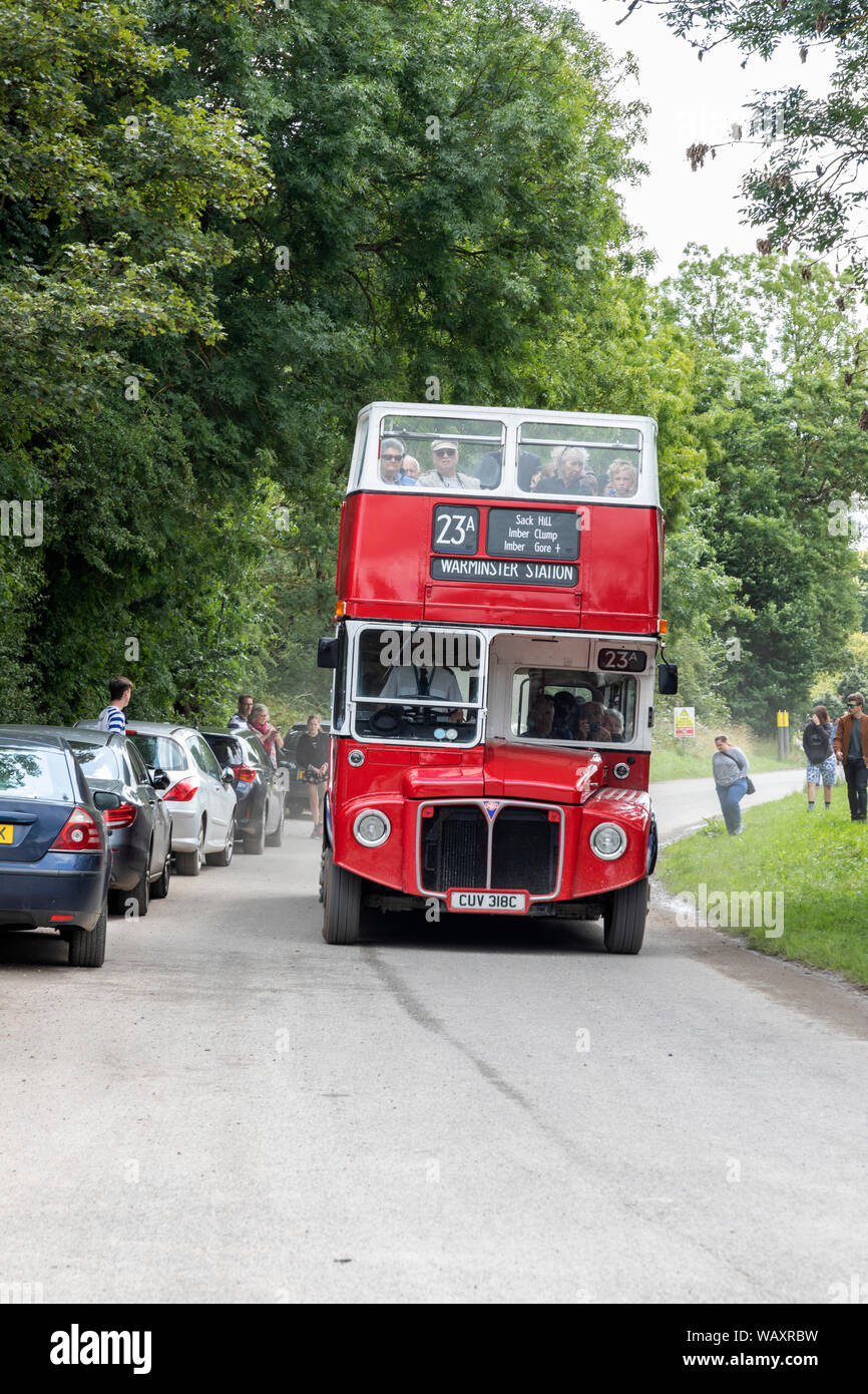 Un autobus rosso Routemaster Imber che visita il villaggio inininadito di Imber, Salisbury Plain, Wiltshire, Inghilterra, Regno Unito Foto Stock